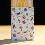 Mom Grass CBG Pre Roll Joints Pack Coming Out From A Chanukah Gift Wrapping Paper