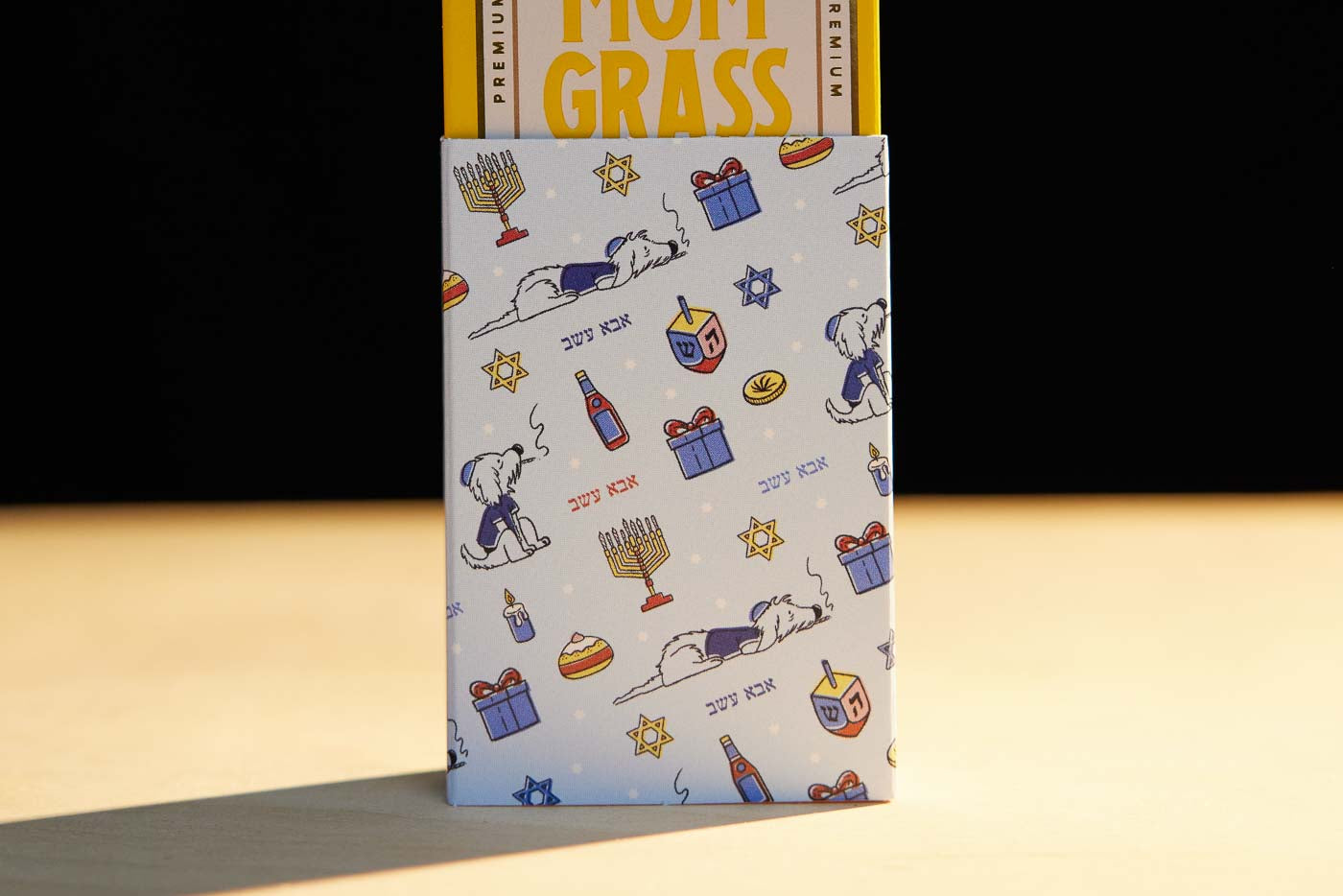 Mom Grass CBG Pre Roll Joints Pack Coming Out From A Chanukah Gift Wrapping Paper