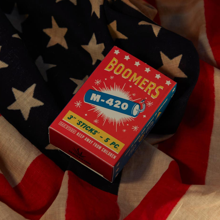 Dad Grass 5 pack hemp CBD pre rolls in Boomers firework sleeve on an American flag