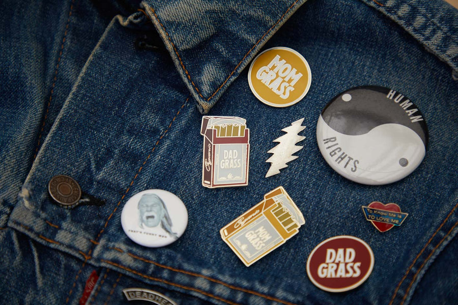 Mom Grass Pack Pin with other pins on a denim jacket