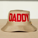Dad Grass Pride 2021 'DADDY CHILL' tan bucket hat. Front view says 'DADDY'