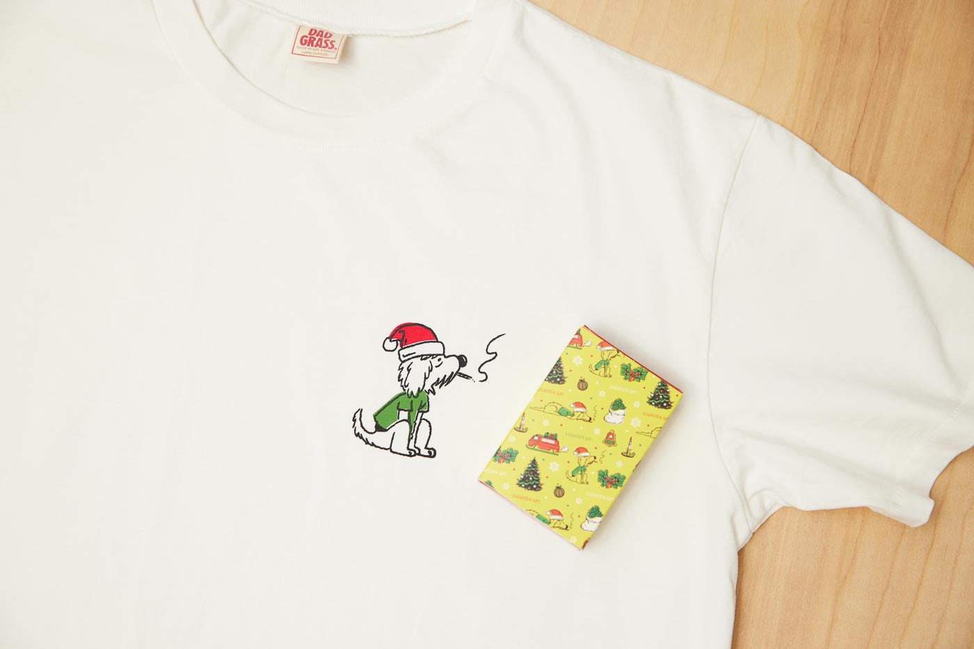 Dad Grass White Santa Rollie Tee And CBD Pre Roll Joints In A Christmas Gift Wrapping Paper