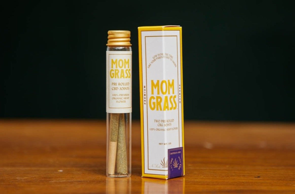 Mom Grass hemp CBG prerolls in a glass vial of 2 next to a hexagonal box