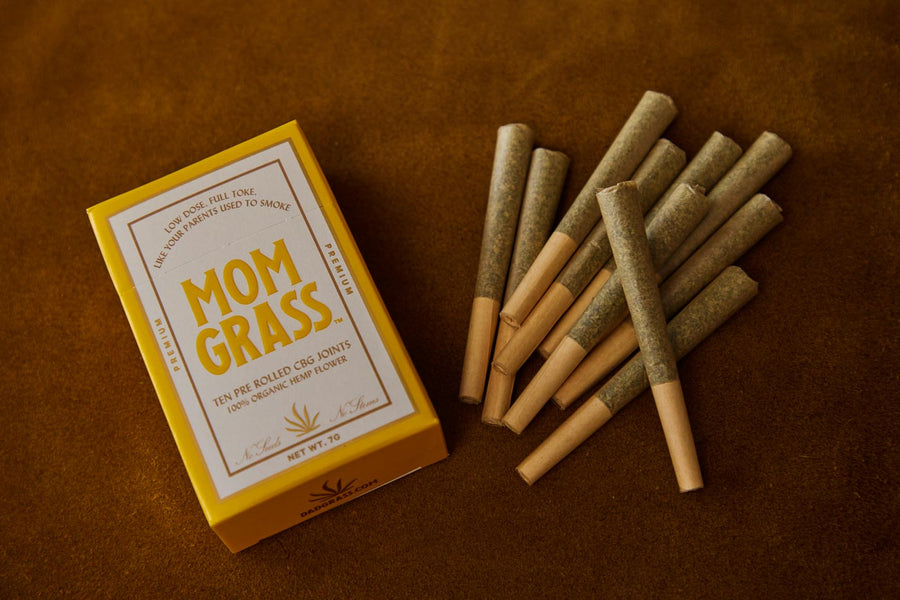 Pre rolls with 10 CBG Hemp Pre rolls in a Yellow Mom Grass pack on a leather sheet