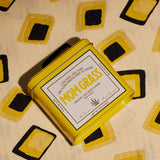 Yellow Mom Grass CBG Hemp Flower Tin On A Yellow Cloth