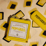 Yellow Mom Grass CBG Hemp Flower Tin On A Yellow Cloth