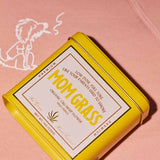 Mom Grass CBG Hemp Flower Half Ounce In A Yellow Tin On A Rollie Hoodie
