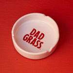 White ceramic ashtray by Dad grass
