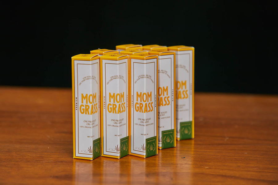 Mom Grass hemp CBG classic joint boxes lined up on wooden table