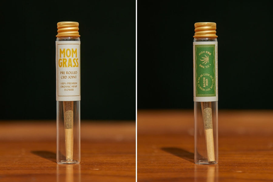 Mom Grass hemp CBG 2 prerolls  in a glass vial next to back side of the same