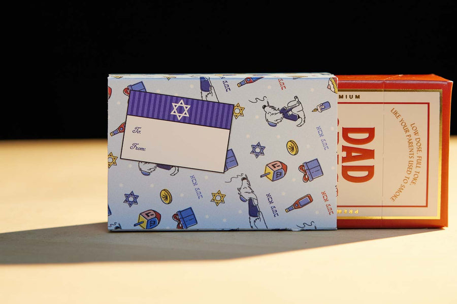 Dad Grass CBD Pre Roll Joints Pack Coming Out From A Chanukah Gift Wrapping Paper 