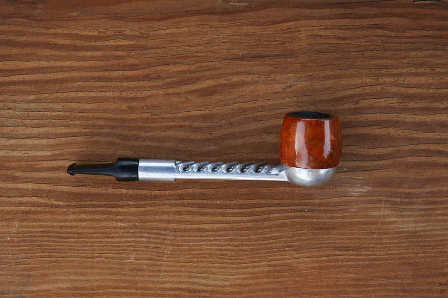 Dad Grass briar and aluminum turbo-flo smoking pipe on a wooden surface