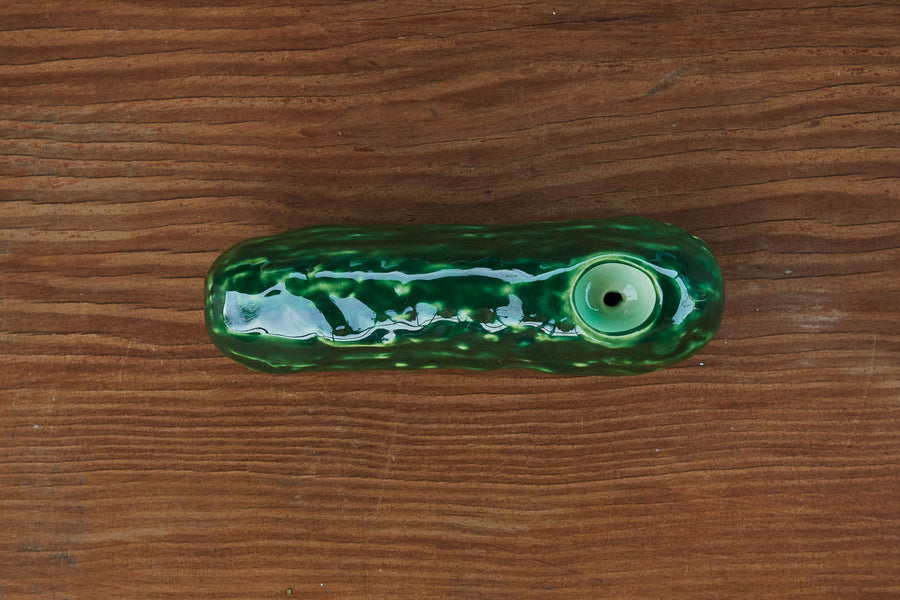 Dad Grass ceramic pickle vintage smoking pipe on a wooden surface 
