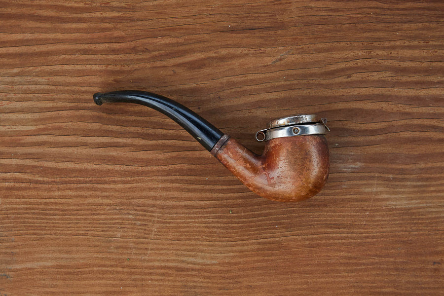 Dad Grass full bent vintage smoking pipe with lid on a wooden surface