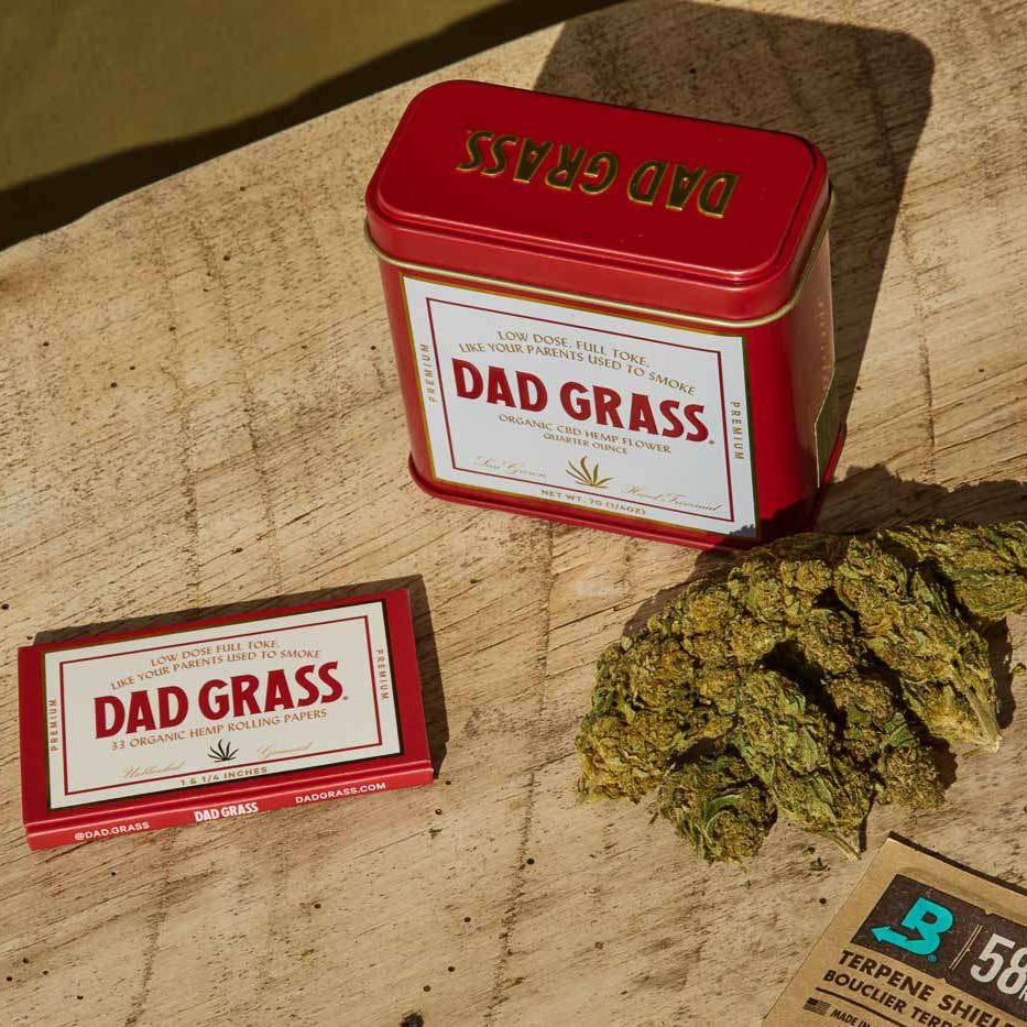 Dad Grass CBD hemp flower And Rolling Paper On A Wooden Table
