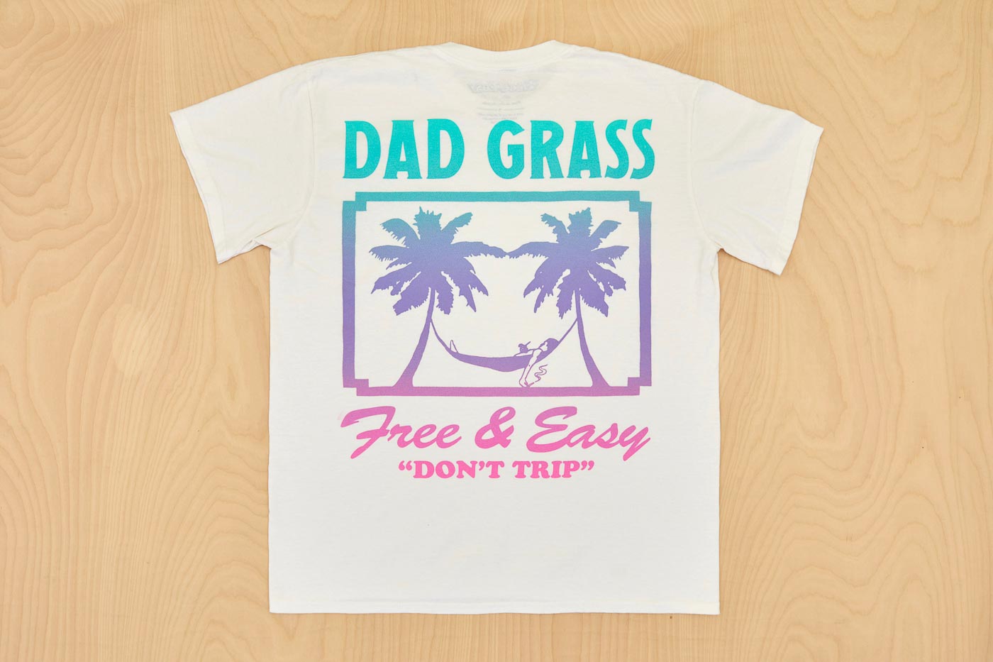 Dad Grass x Free & Easy Summer 2021 White Unisex Tee Shirt back view on wooden table