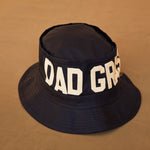 Black Bucket Hat With Dad Grass Written On It And CBD Pre roll On The Side Front View