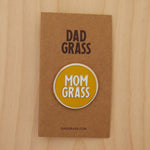 Mom Grass Circle Pin on cardboard on a wooden table