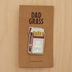 Dad Grass Pack Pin on cardboard on a wooden table