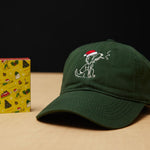 Dad Grass Dark Green Santa Rollie Dad Hat And CBD Pre Roll Joints In A Christmas Wrapping Paper