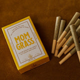 Pre rolls with 10 CBG Hemp Pre rolls in a Yellow Mom Grass pack on a leather sheet