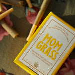 Mom Grass hemp cbg joints and hemp CBG pre roll 5 pack box on a floral tablecloth