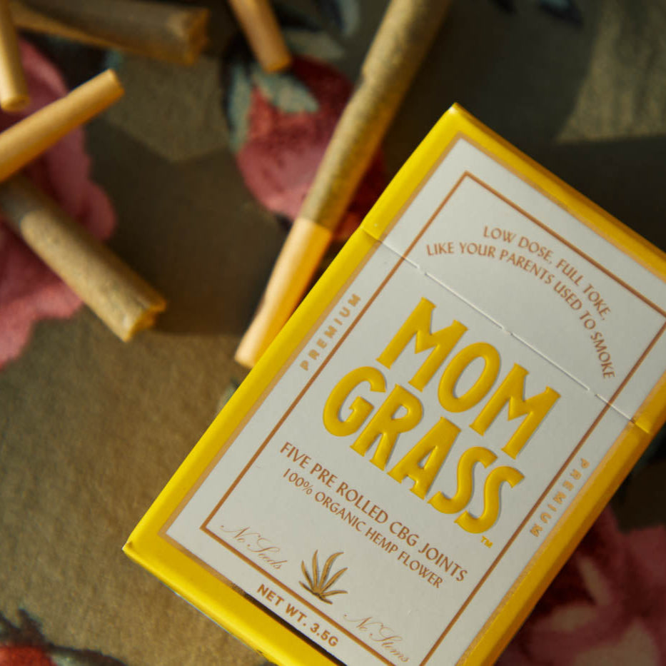 Mom Grass hemp cbg joints and hemp CBG pre roll 5 pack box on a floral tablecloth