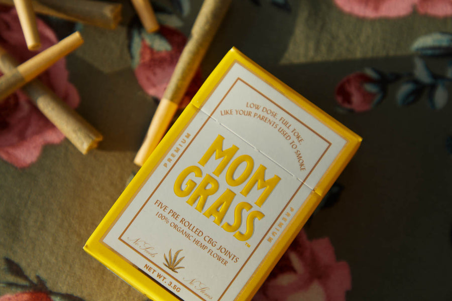 Mom Grass hemp cbg joints and hemp CBG pre roll 5 pack box on a floral tablecloth