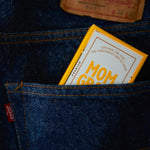 Yellow Mom Grass CBG preroll box in the back pocket of a pair of Levi jeans