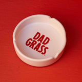 White ceramic ashtray by Dad grass