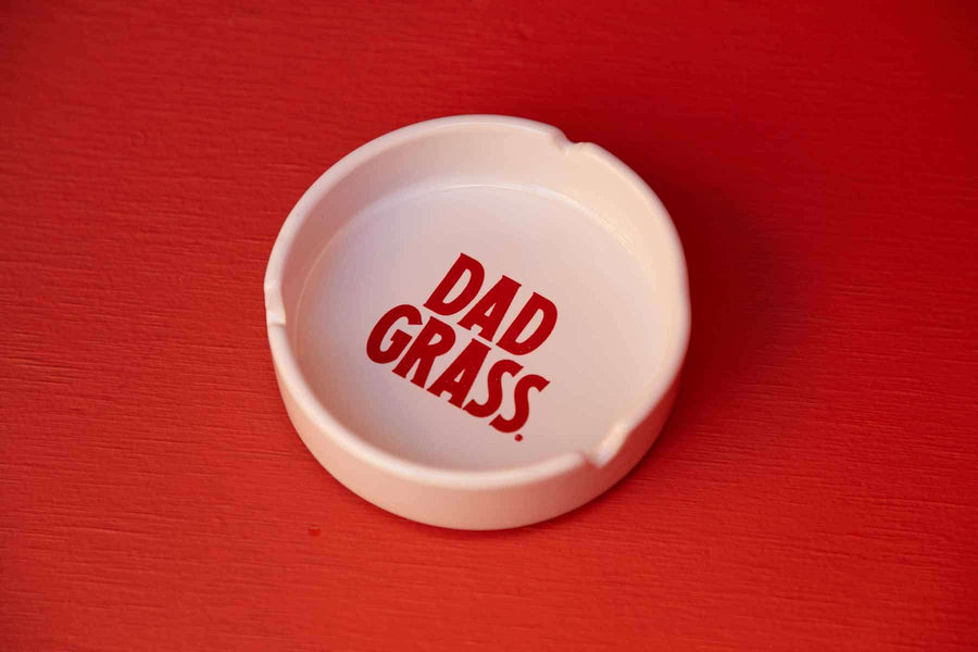 White ceramic ashtray by Dad grass
