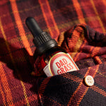 Dad Grass CBD Tincture Classic Formula 30 ML Bottle With 1200 MG Of CBD On A Red Shirt