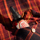 Dad Grass CBD Tincture Classic Formula 30 ML Bottle With 1200 MG Of CBD On A Red Shirt