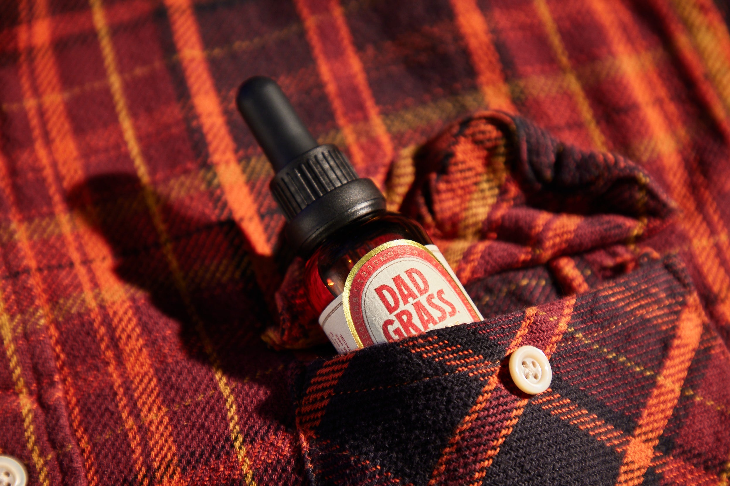 Dad Grass CBD Tincture Classic Formula 30 ML Bottle With 1200 MG Of CBD On A Red Shirt